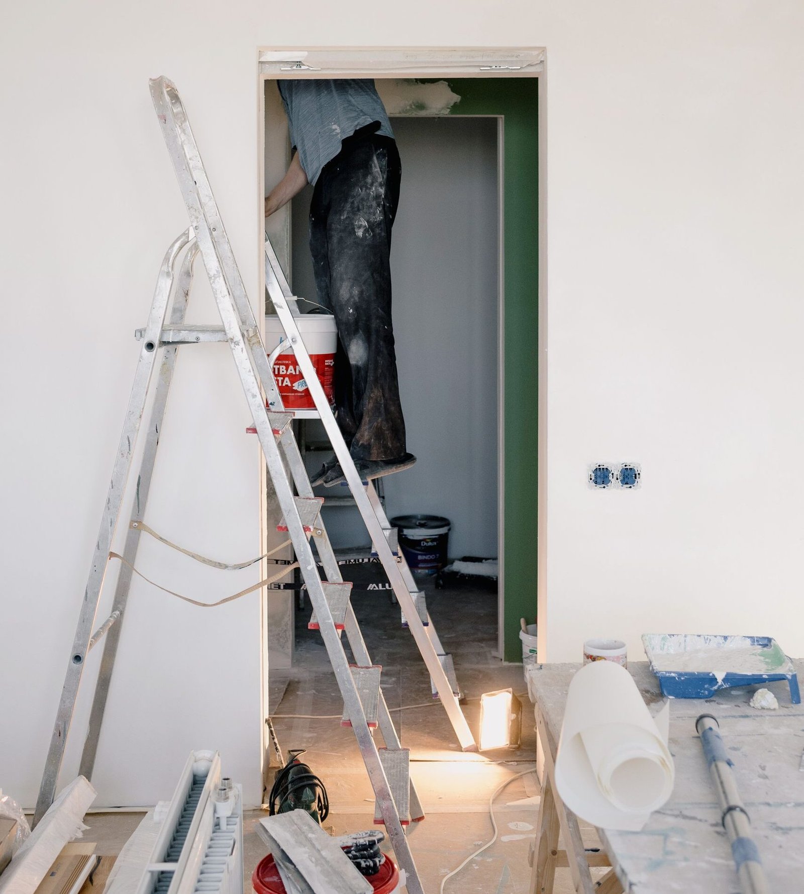 Crop unrecognizable male in dirty clothes working in room during renovation works at home