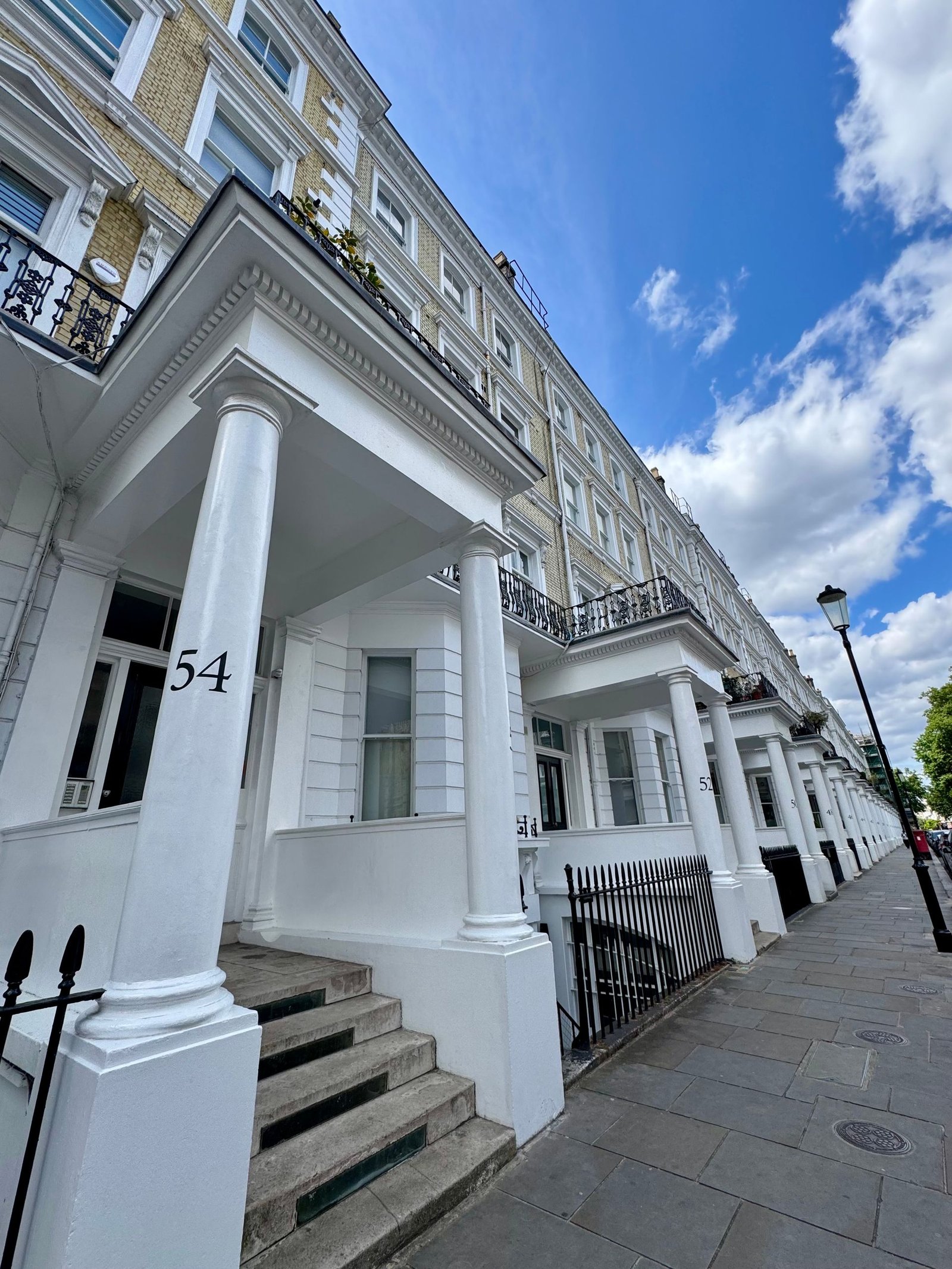 View well maintain of classic Victorian townhouses with ornate columns in a London neighborhood.